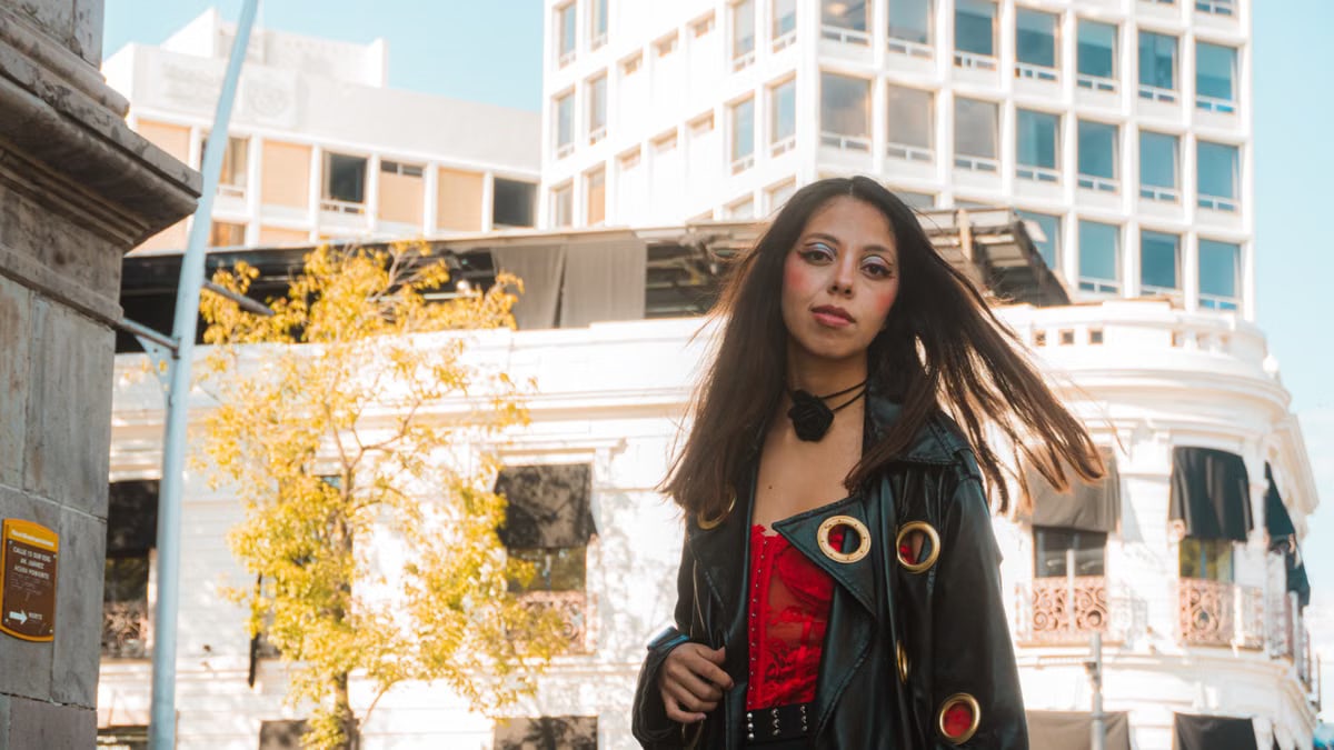 Stylish portrait of a young woman in Heroica Puebla de Zaragoza, against urban architecture.