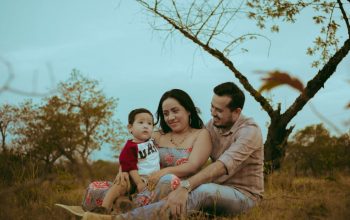 A family of three enjoying bonding time outdoors in a serene natural setting.